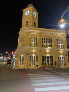 Nachtansicht des Golden Clock Tower in Phuket mit beleuchteter sino-portugiesischer Architektur
