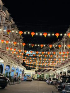 Nachtansicht des Golden Clock Tower in Phuket mit beleuchteter sino-portugiesischer Architektur