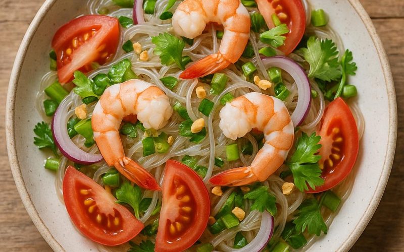 Thai Glasnudelsalat Yam Woon Sen mit Garnelen, Glasnudeln, Kräutern und Limetten-Dressing auf Teller, frisch und scharf